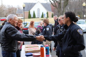 officers and citizens shaking hands at a community event