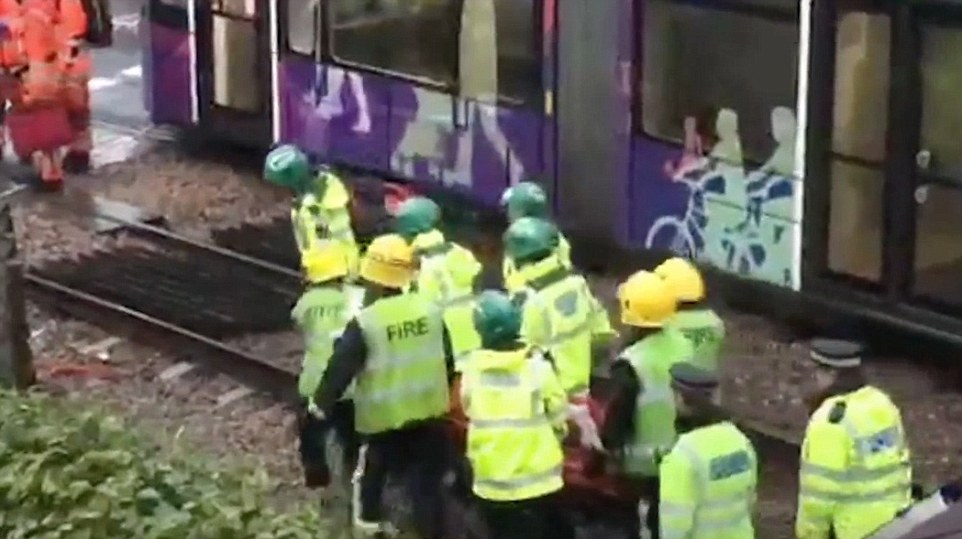 Rescue workers carry away one of the injured following the horrific accident in south London which happened around 6.15am on Wednesday morning