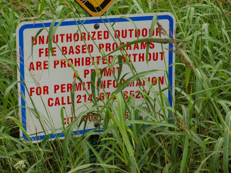 A Sign With Important Information Is Decorated With Nature`s Charms. A very important sign of a city ordinance could be missed, but not so easily. The red stock photo